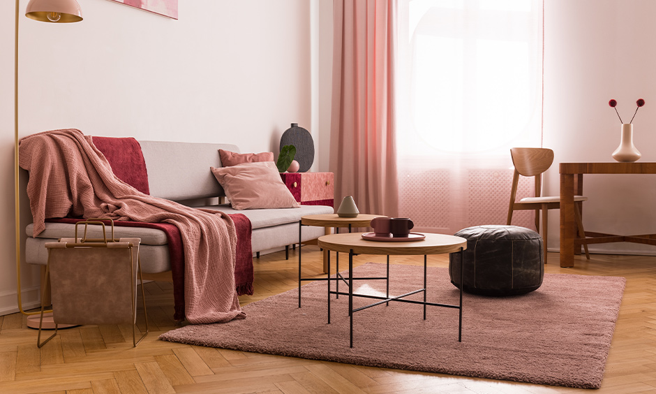 The living room has multiple shades of pink color combination for the wall with pink lampshades, pillows, and drapes.