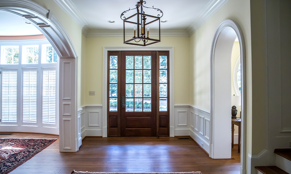 Old-style foyer area in cream home colour matching with white wainscotting brings vintage feel.