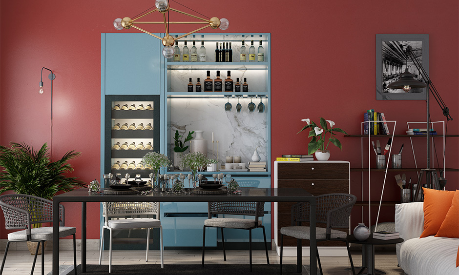 Dining room in dark pink color combination for wall with blue and grey furniture adds bold to space.