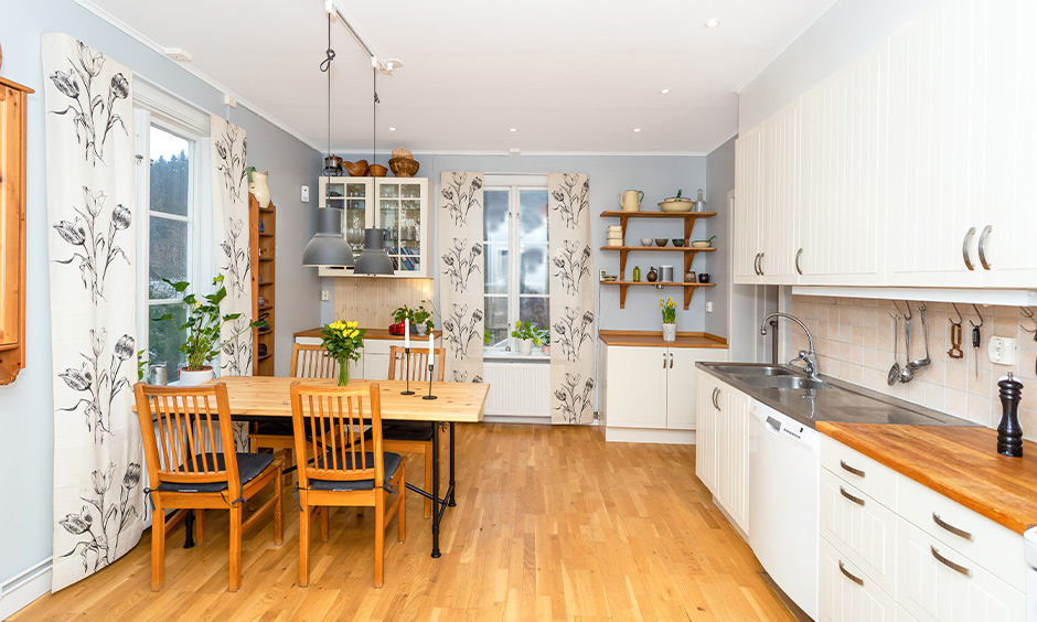 Unique themed kitchen cum dining area with floral wall designs in modular kitchen design.