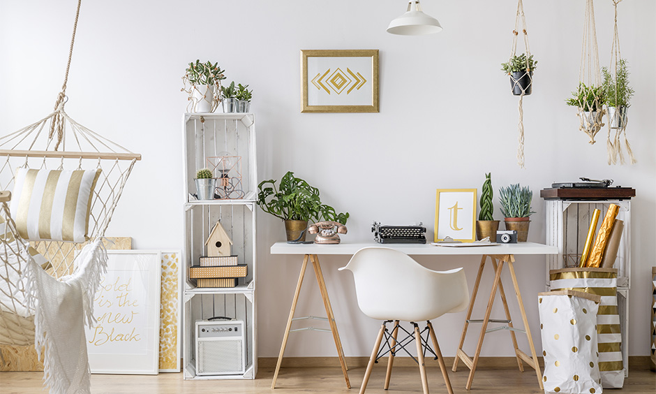 All-white study room decoration with indoor plants, photo frames, wooden rack and jute hammock swing add an old-school vibe.