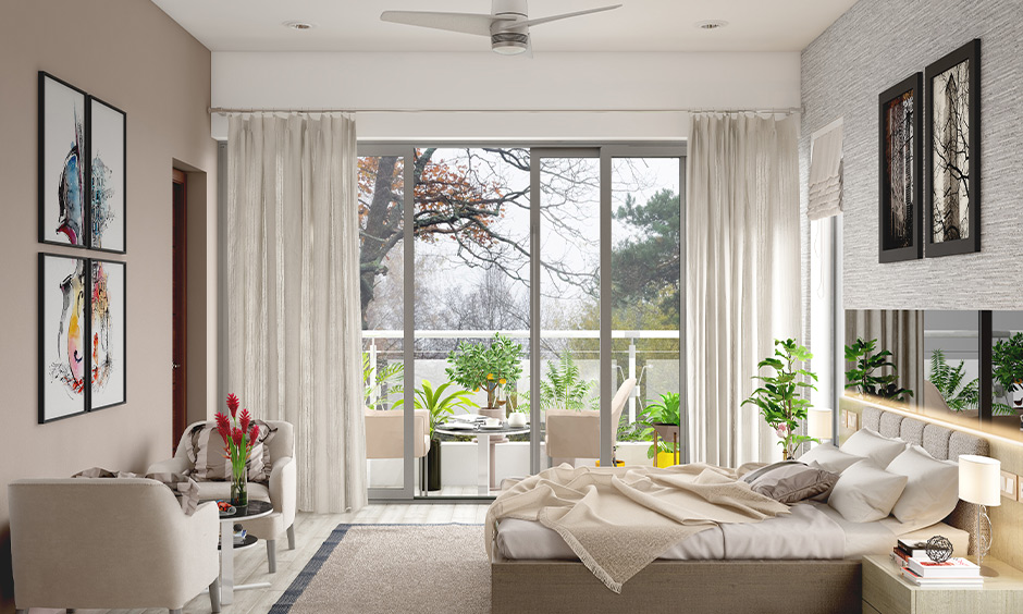 An aluminium glass sliding door designed between bedroom and balcony with white curtains lend a sleek look.