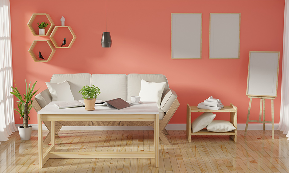 Coral pink summertime paint color for the living room creates a soothing atmosphere with wooden flooring.