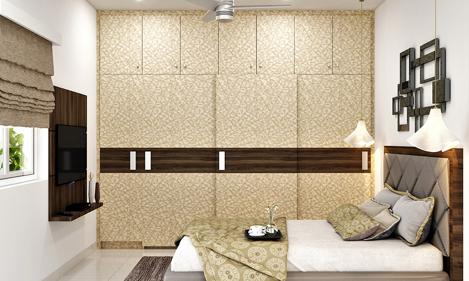 Full wall wardrobe design in beige and brown colour with sliding doors brings an aesthetic look to the bedroom.