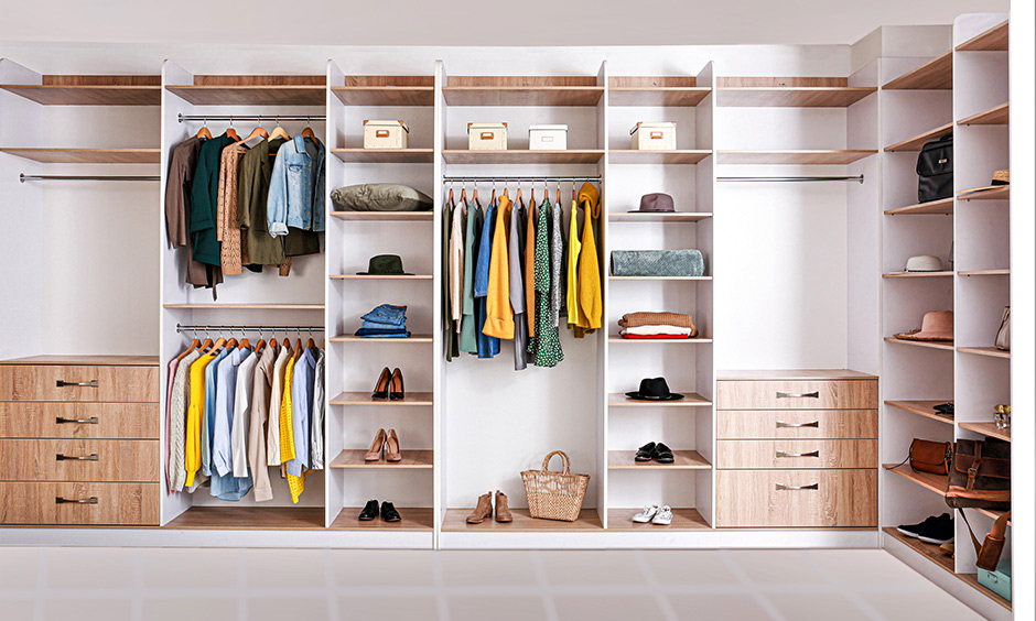 How to organize women's wardrobe- White L-shaped open closet with different shelvings makes it easy to access.