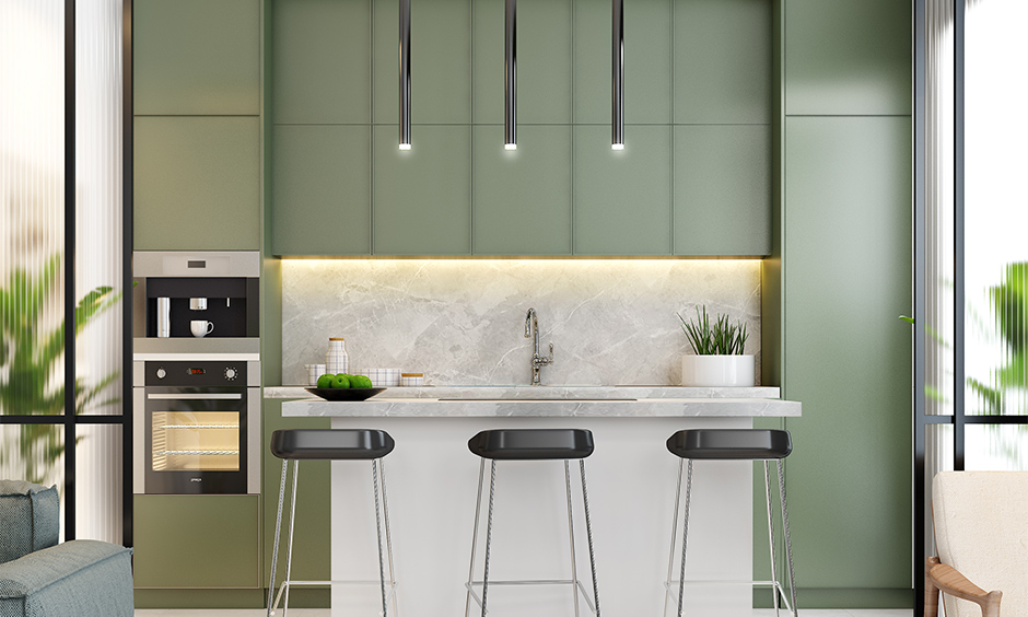 Island Indian open kitchen design in olive green and marble breakfast countertop looks elegant.