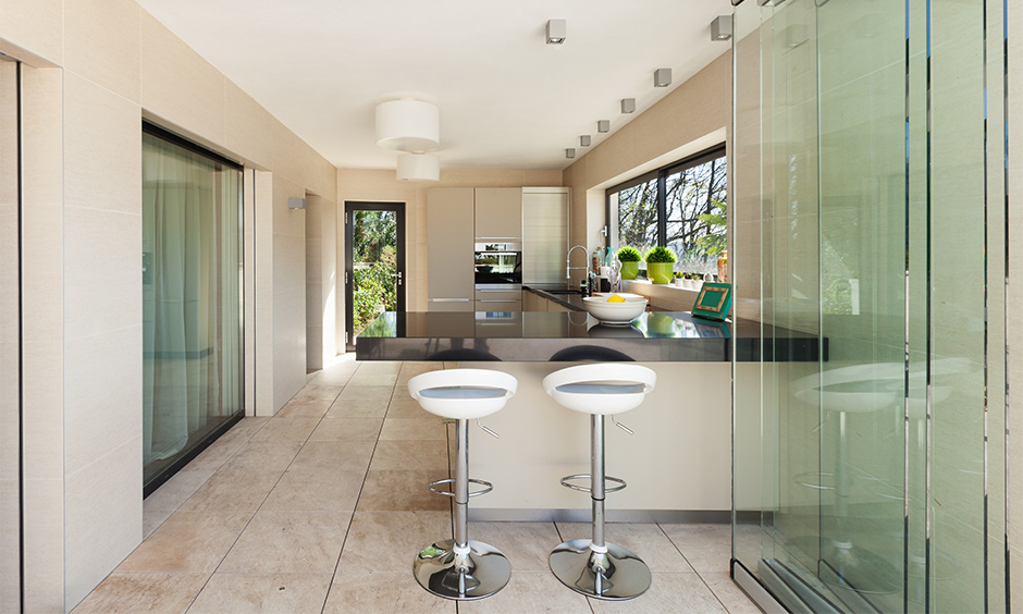 The partition between the living and kitchen with sliding glass door design lends a chic look to the area.