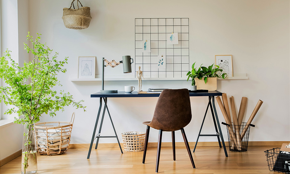 The small study room has a metallic table, floating shelf, fancy table light and plant in the study room decoration .