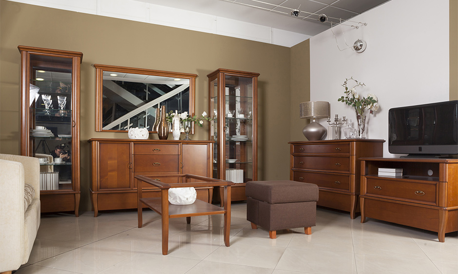 Vintage wooden showcase design for hall with glass door adds classic look with elegant furniture in the living room.