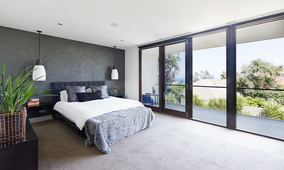 The bedroom's glass sliding door design with a wooden frame lends an elegant look and chic wooden glass sliding door design.