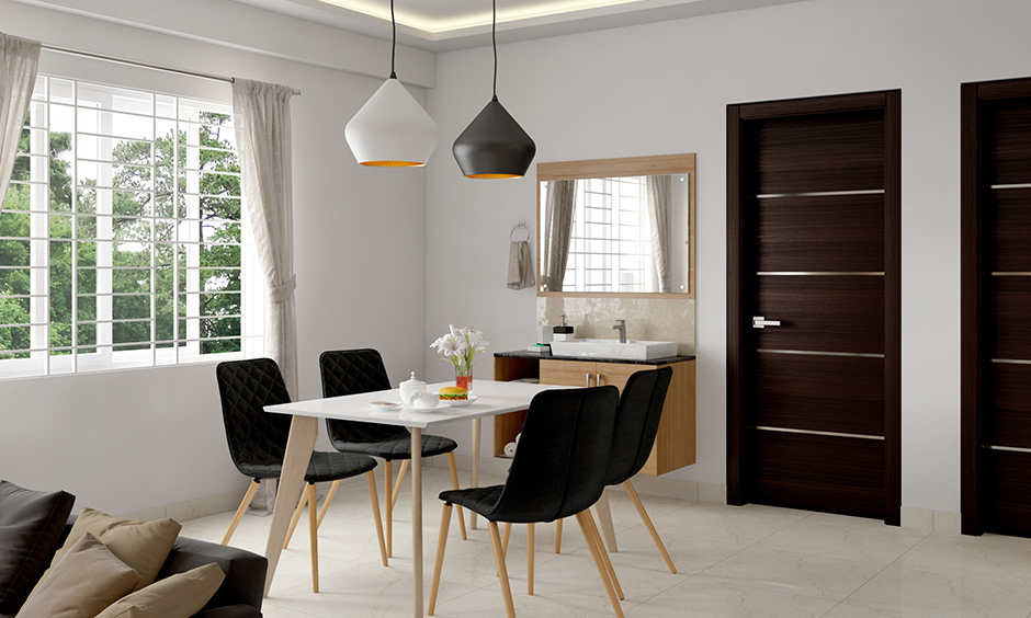 White minimalist open dining room design with black dining chairs and the pendant light lends a classic look.