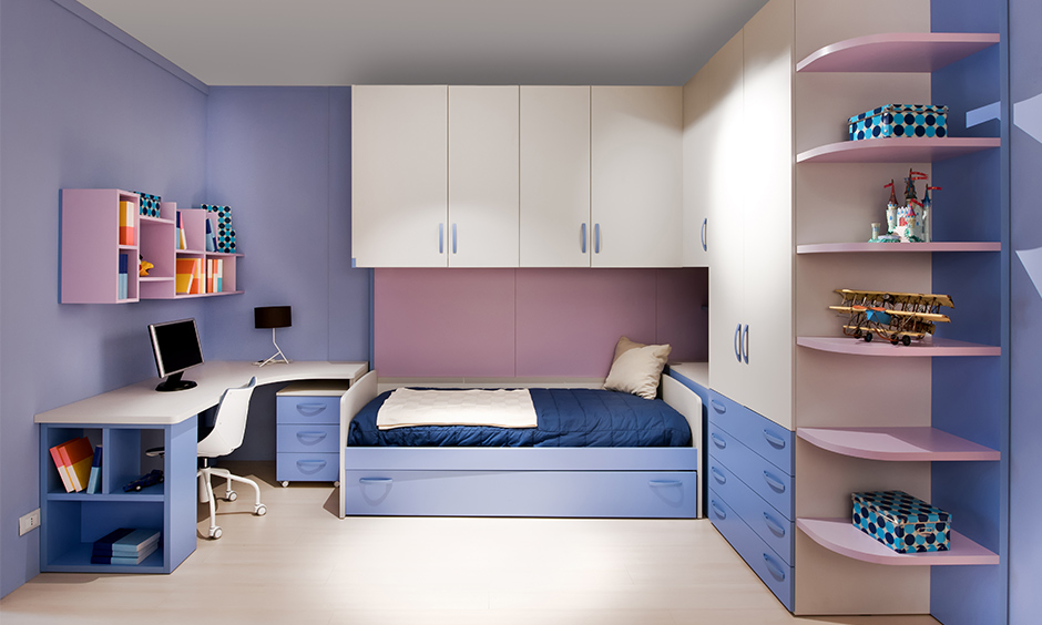 Corner l shaped wardrobe design in white, pink and blue combination lends a sleek look to the children's bedroom.