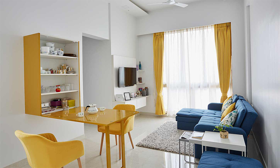 A small living room cum dining area with a yellow foldable dining table is creative space-saving living room furniture.