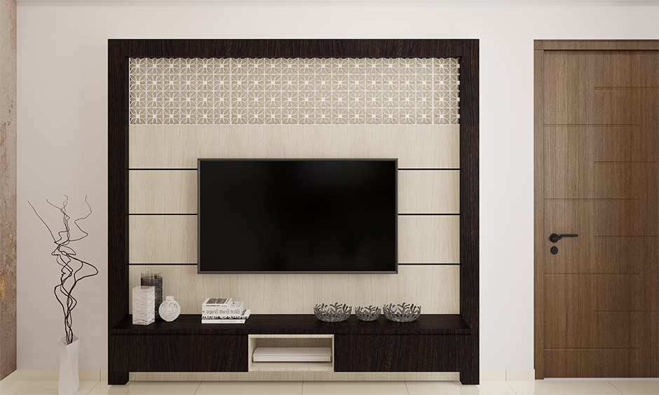 The tv unit background is decorated in a jali pattern and a dark wooden frame; that is how to decorate the TV unit.