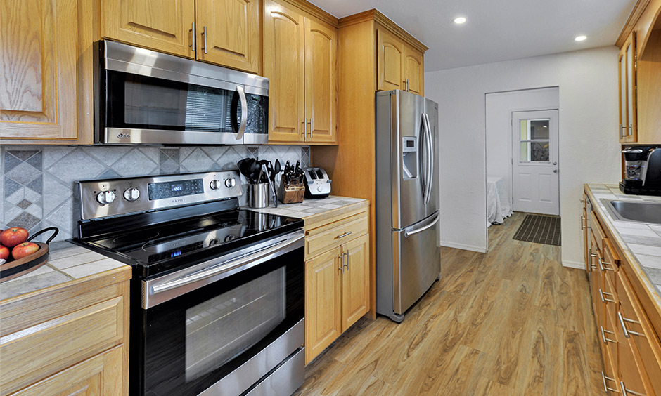 Parallel kitchen cabinets Indian style made from wood with backsplash tiles lends a rustic look.