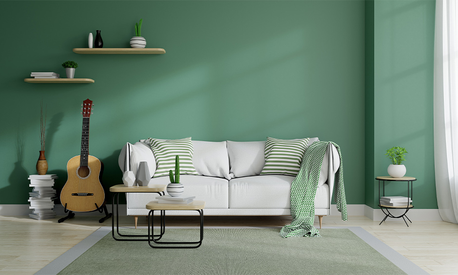 Living room in mid-century modern interior style with the green wall colour and potted plants brings in a fresh vibe.