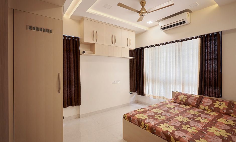 Off-white minimalist bedroom design with floating cabinet in beige colour creates a very soothing ambience.