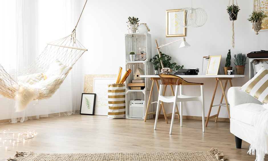 Scandinavian living room with a hammock, wooden flooring and hanging plants creates a beach vibe.