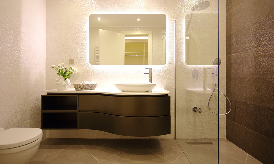 Modern bathroom vanity designs with a backlit mirror, a petite sink and the curvy cabinet look beautiful and sleek.