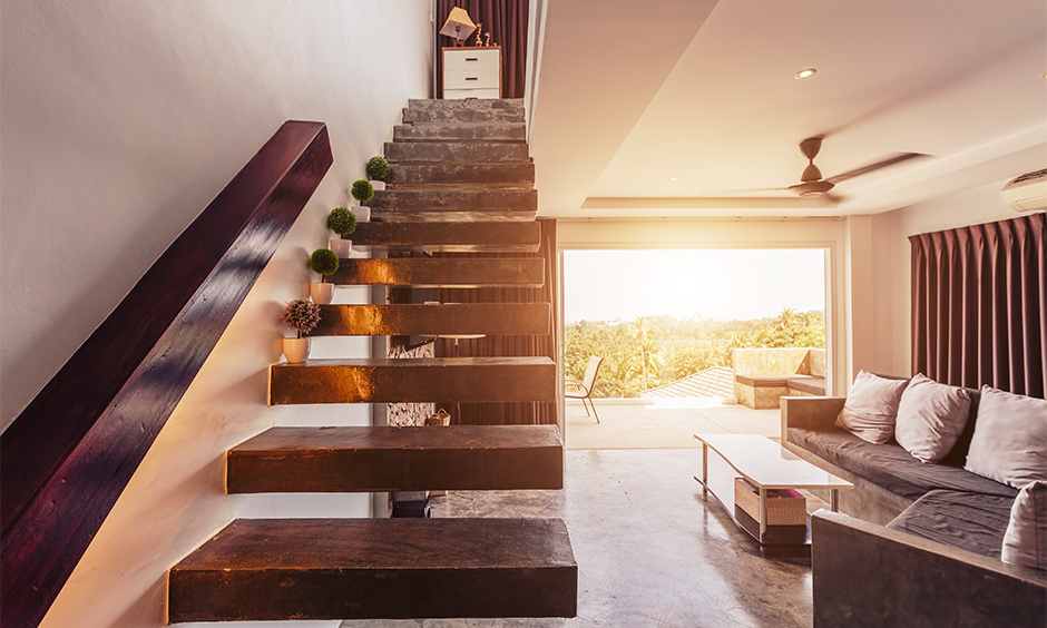 A small living room with stair with floating wooden slats uplifts the home's aesthetic and lends charming vibes.