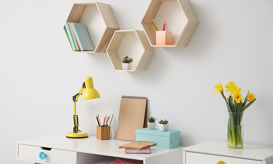 The study room with wall shelves above the table is a practical study table organization and enhances the look.