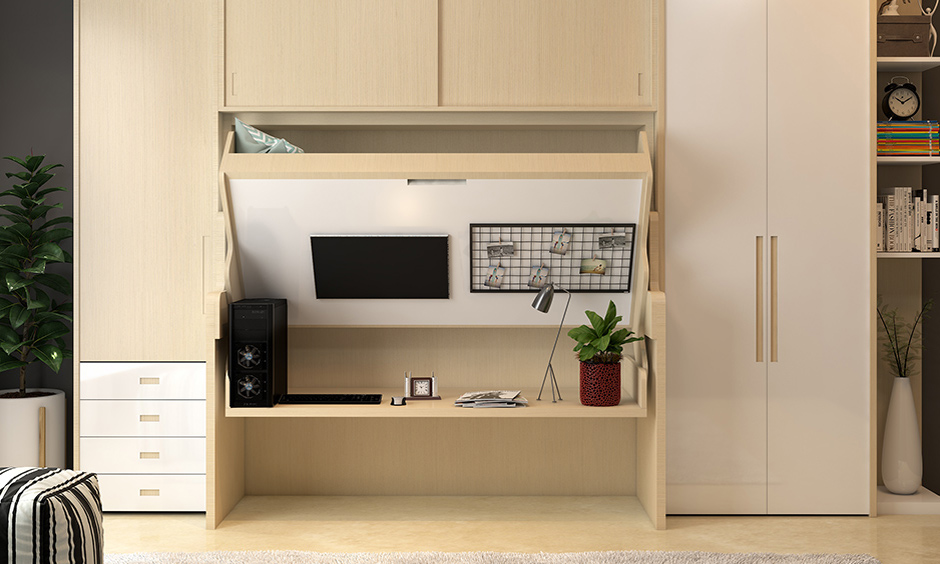 Multi-purpose furniture idea, wardrobe cum study desk cum bed in the wooden finish is the space-saving design.