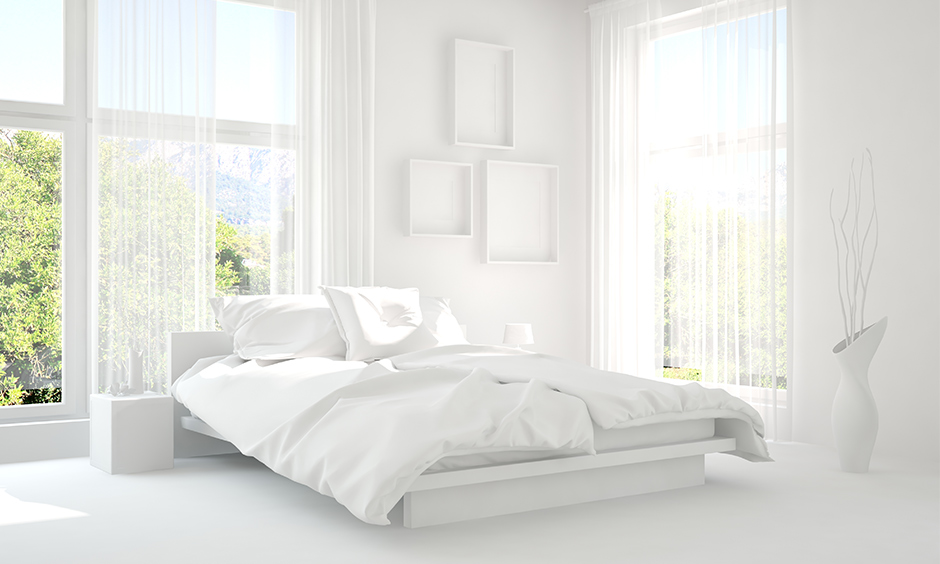 All-white minimalist bedroom design with window frames, the flower vase and the side lamp, look clean and chic.