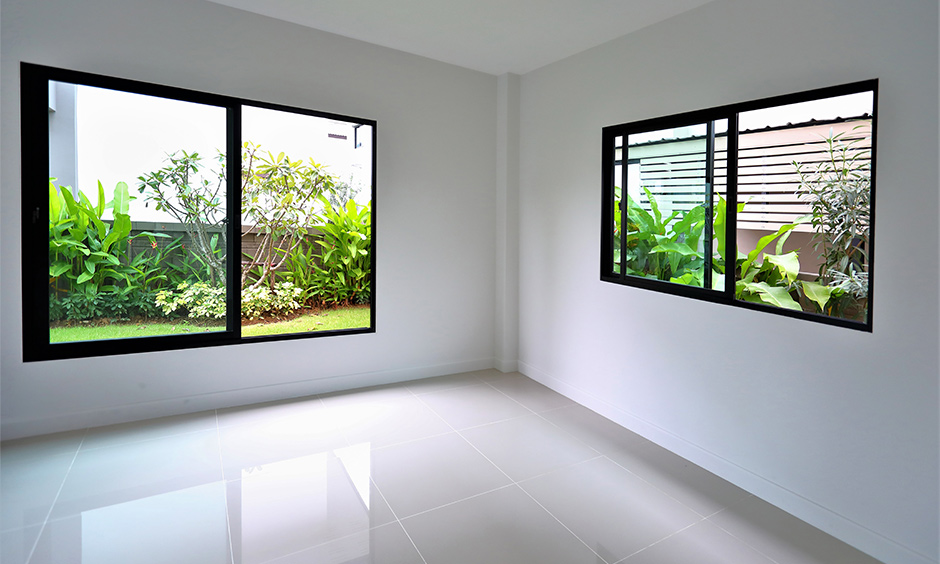 Sliding window glass design with a black window frame in the white room lends a chic look to the area.