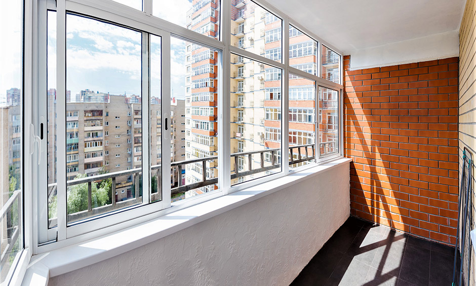 Multiple window sliding glass design in the balcony paired with a brick wall on the side lends an elegant look.