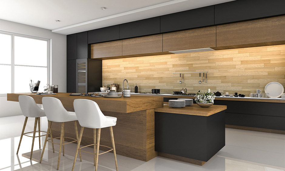 Wooden interior for the kitchen of Indian style in white colour with breakfast counter looks minimal and clutter-free.