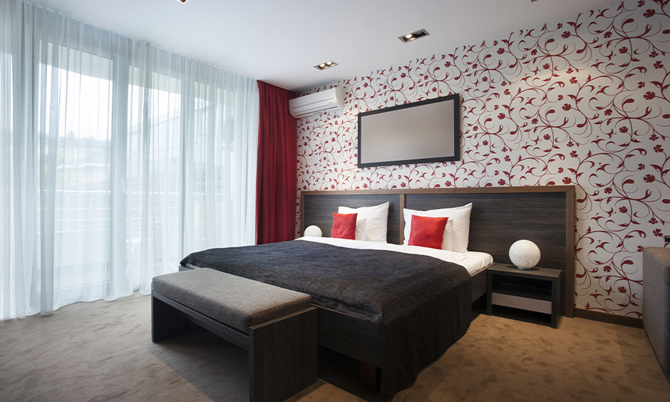 Red wall bedroom idea, the bedroom has red floral patterned wallpaper and curtain gives a cleaner look to space.