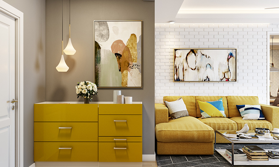 Modern entrance hall idea, foyer area design with yellow cabinet unit and painting on the wall lend an artistic vibe.