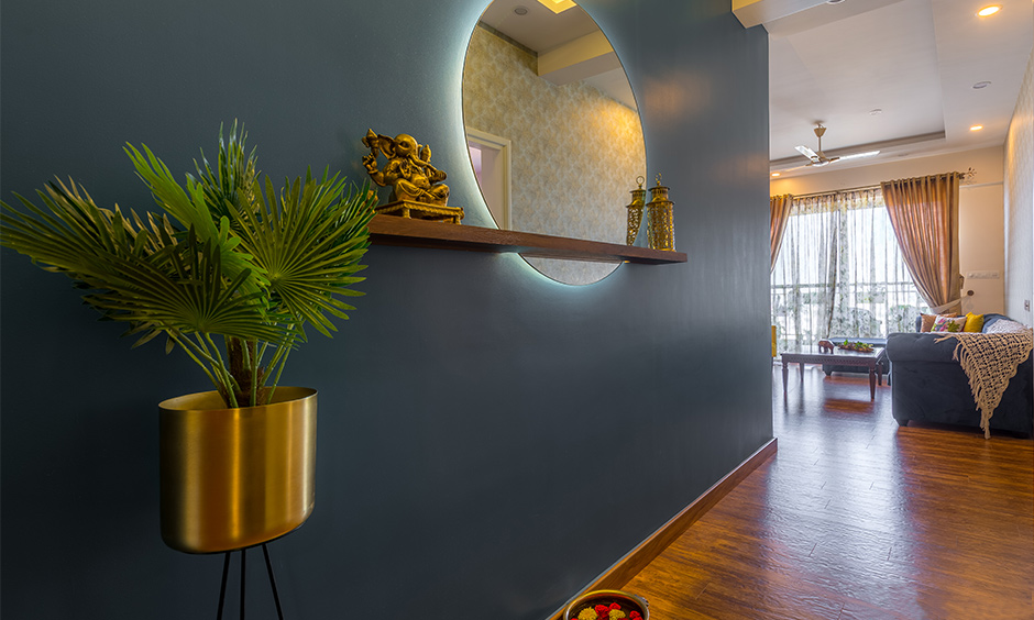 The foyer designed with an LED-lit mirror, floating shelf and indoor plants are the modern entryway idea.