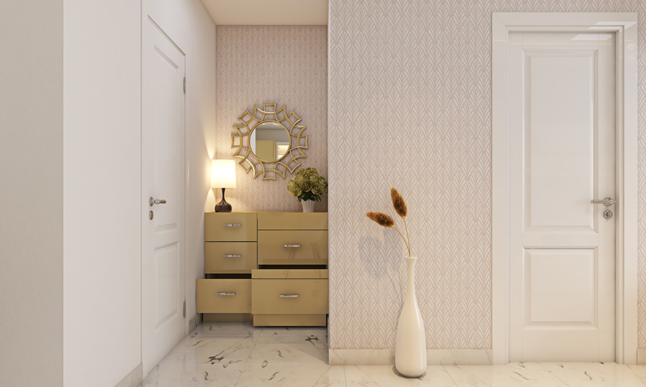 A small foyer design with a metal wall mirror and storage unit is the perfect modern foyer design for a tiny apartment.