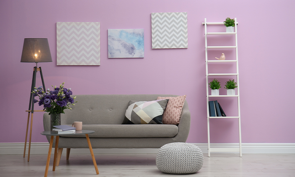 Small living area in purple wall colour combinations with grey sofa and white decor element adds an elegant look.