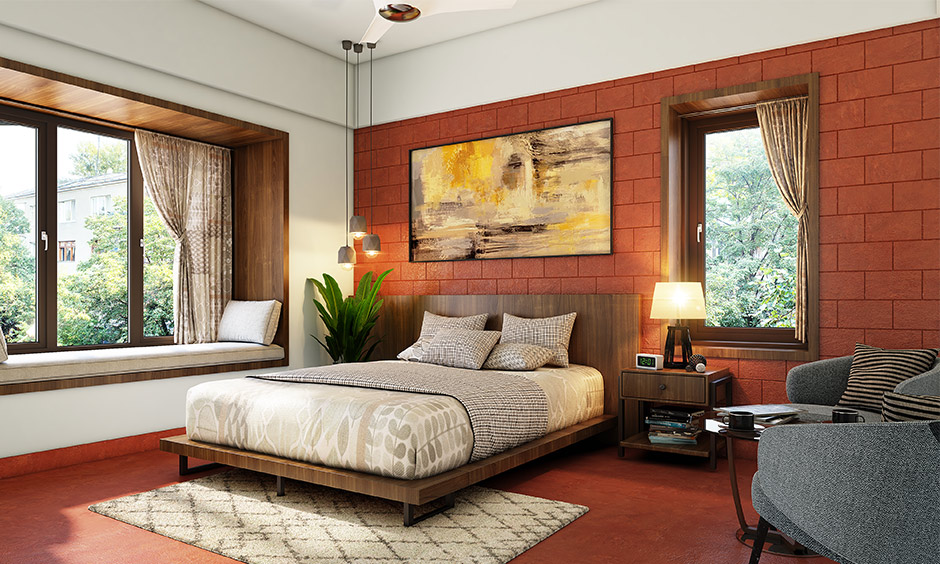 Brick cladding wall in red bedroom with red oxide flooring lends a traditional touch to space.