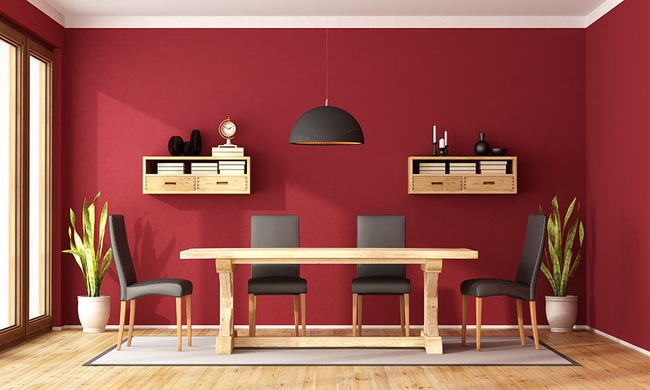 Red wall paint combinations with black and wooden shade furniture bring a vibrant look to space.