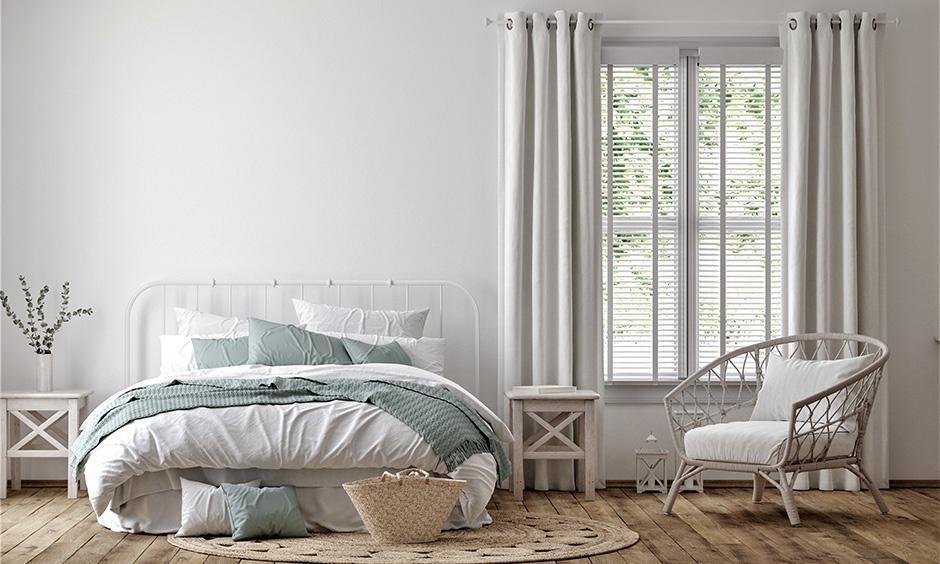 White farmhouse bedroom decor with wood flooring and minimal furniture makes the space look visually larger