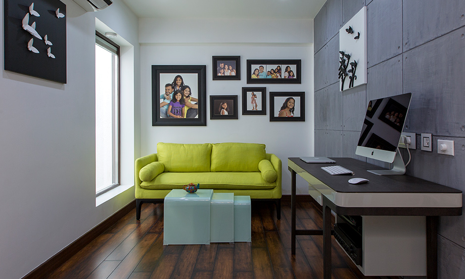 Small villa design in India, personalised corner room designed with desk, frames on wall and couch looks elegant.