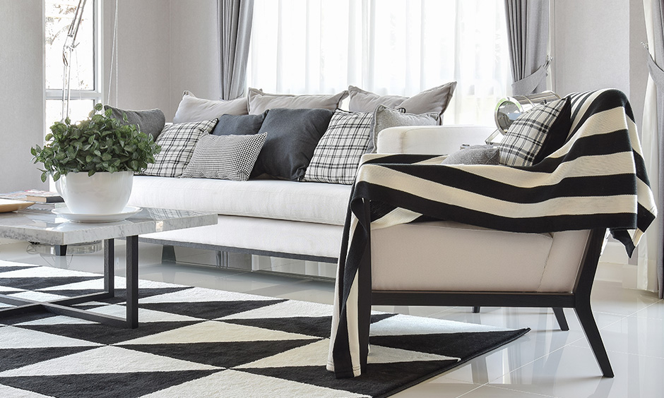 White room with upholstery in vintage look interior design with pattern cushions in black and white.