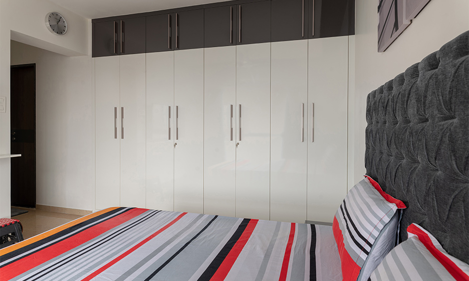 Minimalistic black and white interior design bedroom with wardrobe creates a striking appearance against white wall.