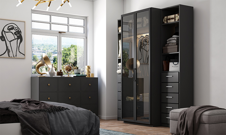 Bedroom in a black and white interior with wardrobe and painting framed in gold adds a vintage feel.