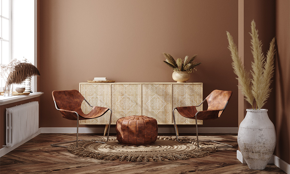 Room with bohemian tribal decorated brown chair, pouffe and boho vase add a quintessentially tribal appeal to space.