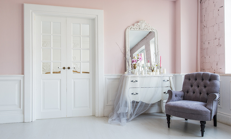 Classic dressing table corner design in white colour is effortless yet attractive against a pink wall.