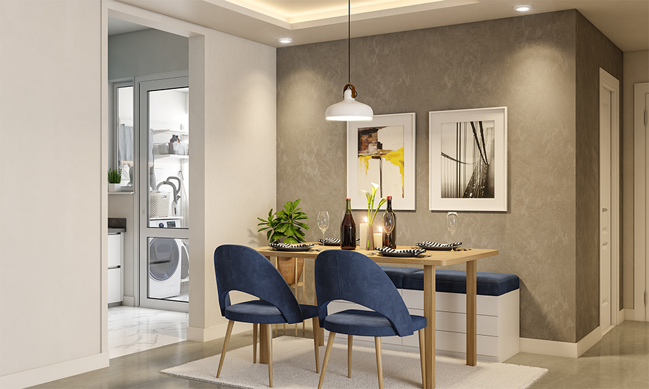 Grey dining room walls paired with blue chairs stand out and blends very well.