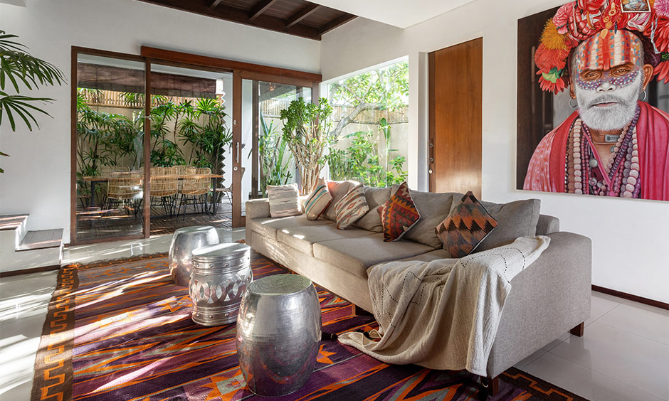 The living room has tribal decorated large portraits and stools that help bring in the native charm to the home.