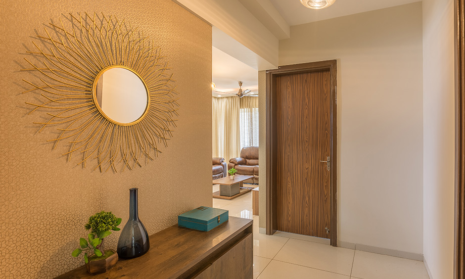 Two-toned wooden panel main door design with a smooth gradient textured laminate gives a rustic edge to the room.