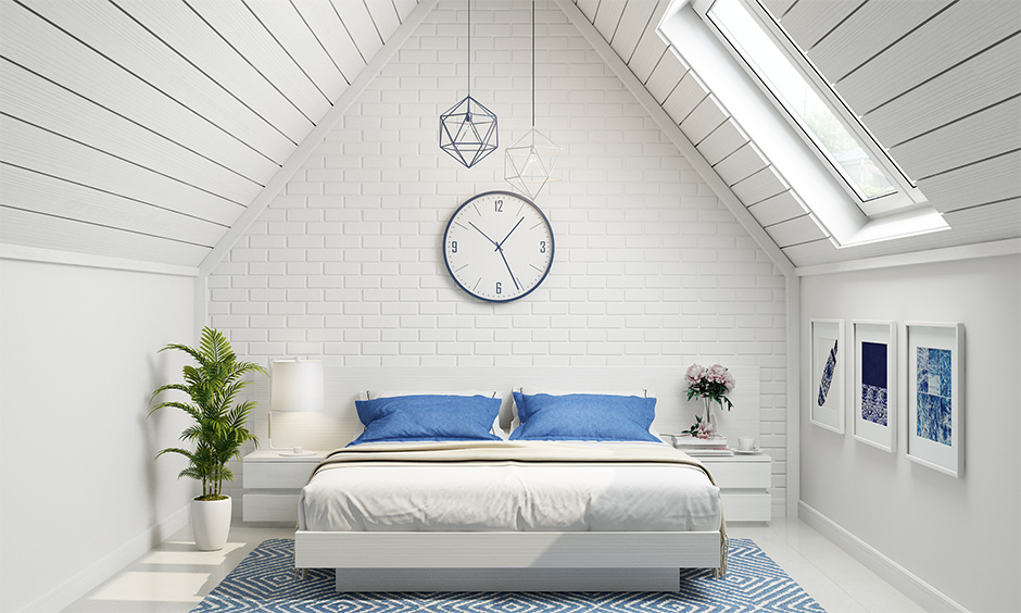 Classic white attic bedroom designed with a pop of blue elements looks very spacious and airy.