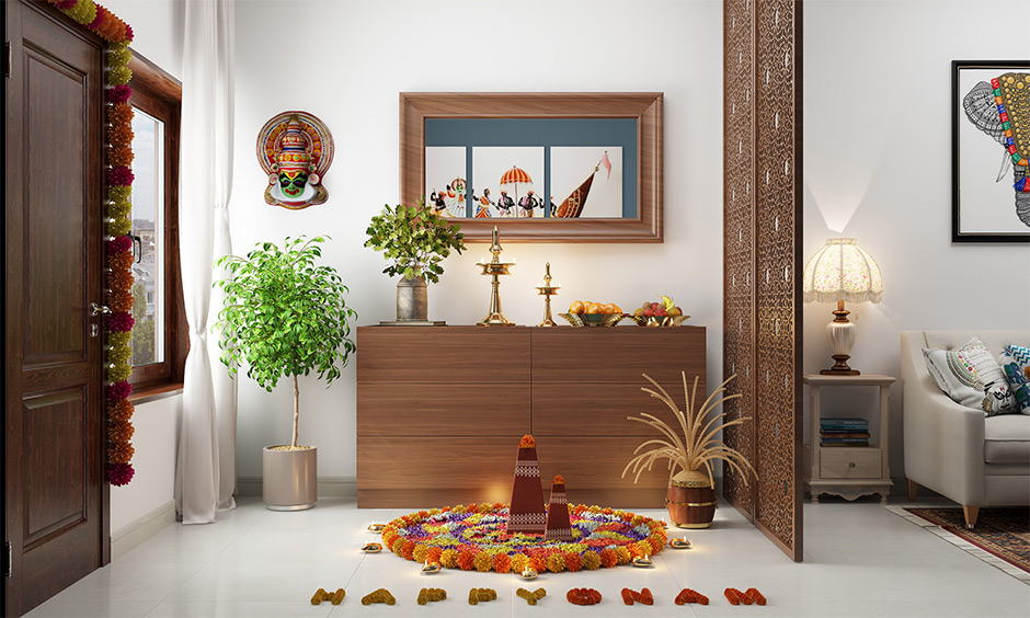 Onam decoration for entryway with floral rangoli, tall brass lamp and Kathakali face