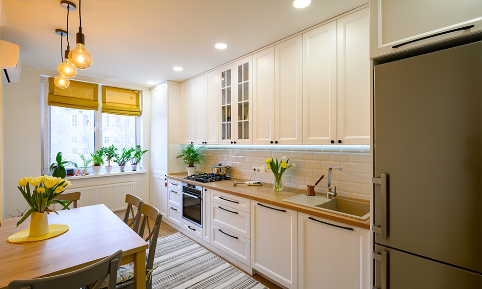 Modern straight kitchen design with white wooden cabinets and large pantry cabinet